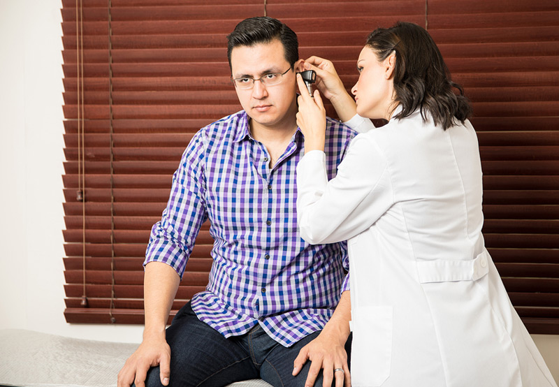 doctor-examining-patient-before-providing-hearing-aids